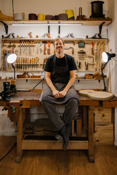 Young luthier crafting Spanish flamenco guitars in workshop