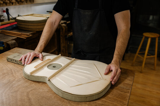 Young luthier crafting traditional Spanish flamenco guitars
