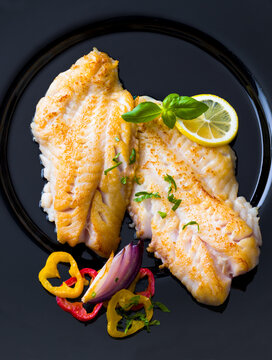 Fried redfish fillets served with fresh lemon and vegetables