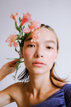 Close-up portrait of a young woman with flowers in her hair