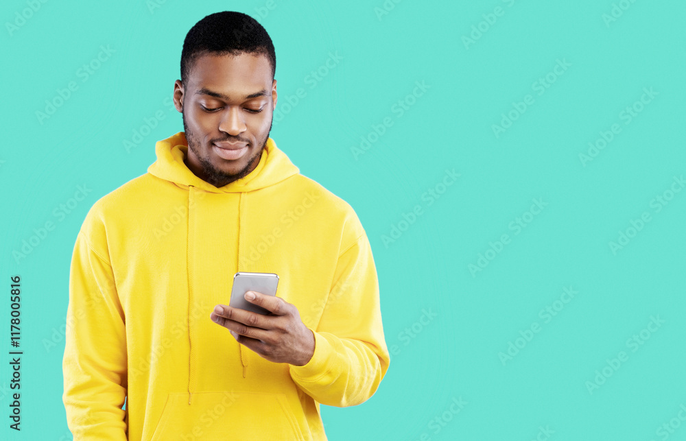 Poster black young man using smartphone texting in social media or using new mobile application standing ov