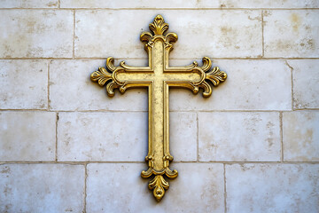 A gold cross on a white brick wall