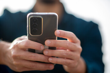 Close-up of hands using a smartphone outdoors