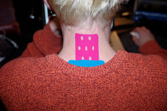 A young man wearing colourful kinesiology tapes 