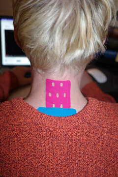 A young man wearing colourful kinesiology tapes 