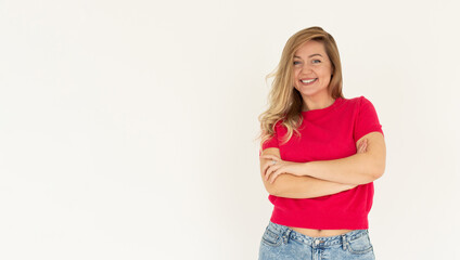 Image of cheerful woman in basic t-shirt smiling at camera while standing with arms crossed...