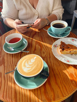 Table with three cups of coffee and tea.