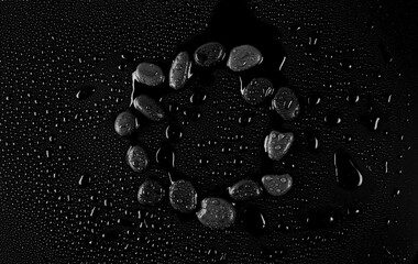 Frame oval stones with water drops on black background	