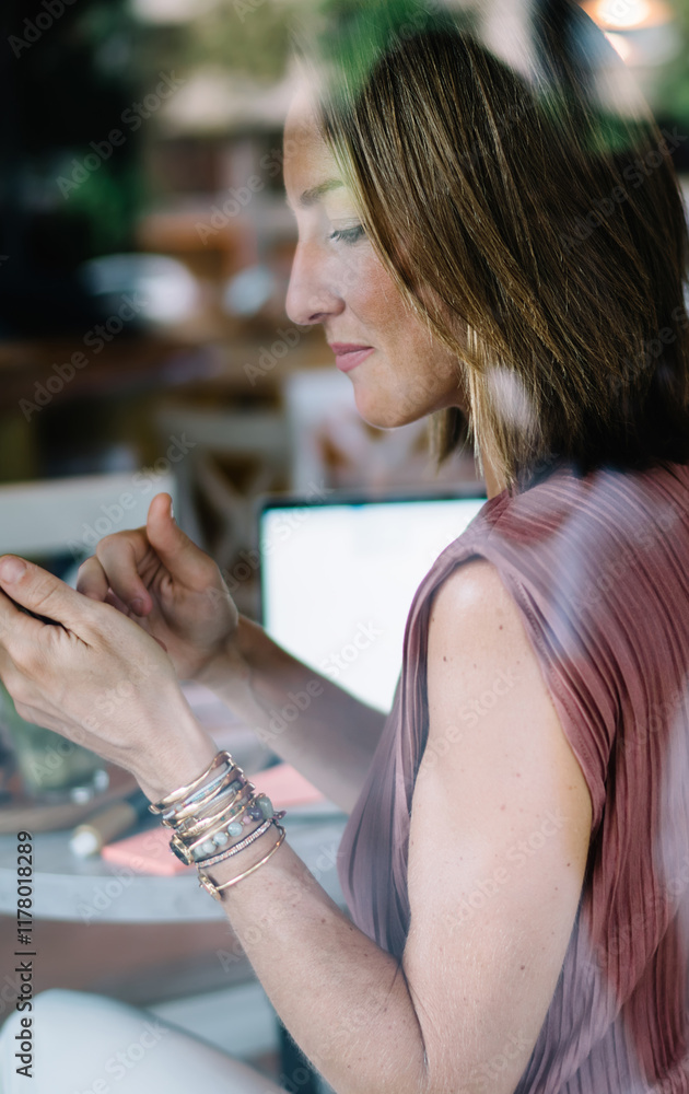 Poster rear view of female blogger using mobile phone for checking mail and messages notification on break,