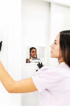 Dentist supervising panoramic X-ray procedure