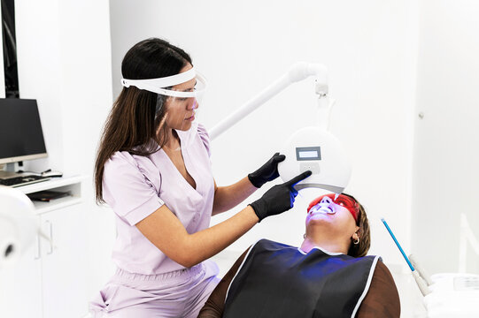 Dentist operating teeth whitening lamp