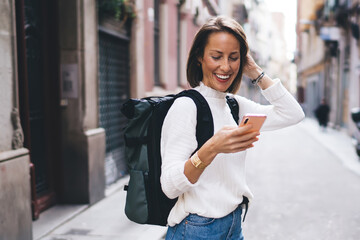 Positive woman using smartphone on street