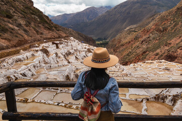 Latin tourist looks at the Salar de Maras, an ancient Inca salt flat in Cusco