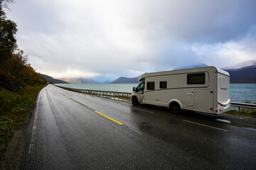 A motorhome parked by the road in the autumn landscape of the Lyngen Alps, Northern Norway, with mountains.