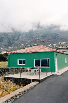House with a woman relaxing on the porch in the village of Frontera
