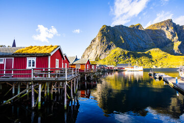 Fototapeta premium A beautiful sunrise over the picturesque village of Reine in Lofoten Islands, Norway, surrounded by dramatic mountains.