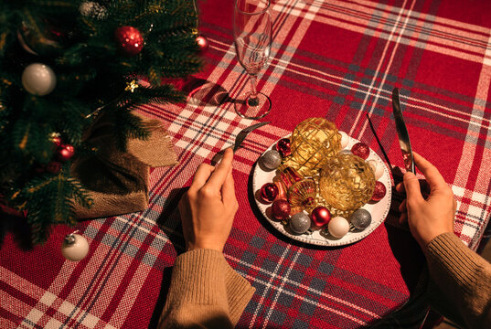 Woman's hands with fork and knife with the decoration Christmas plate.