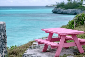 Fototapeta premium A pink picnic table situated on the edge of a cliff, perfect for scenic views and outdoor dining