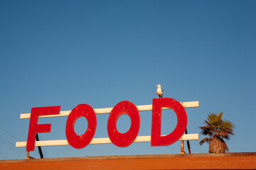 Vintage Food Sign Against Blue Sky
