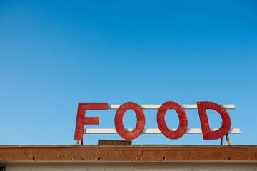 Vintage Food Sign Against Blue Sky
