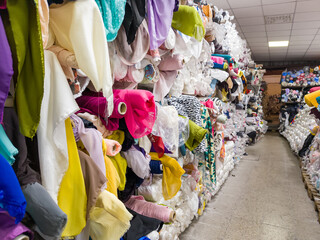 Colorful Rolls of Fabric in a Textile Warehouse. Fabric and cloth store with sewing and crafting...