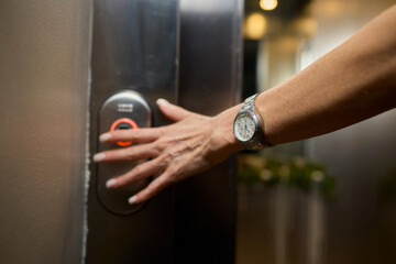 Obraz premium Pressing the elevator button in contemporary high rise buildings signifies modern urban convenience