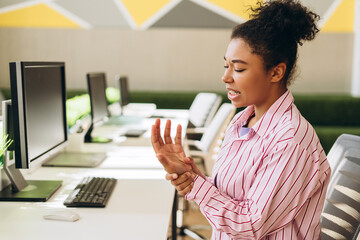 Office worker experiencing wrist pain while working on computer