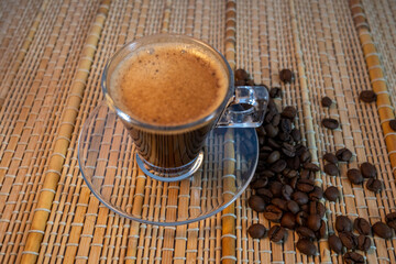 coffee and coffee beans on a straw tablecloth during an afternoon or morning coffee with beans arranged around