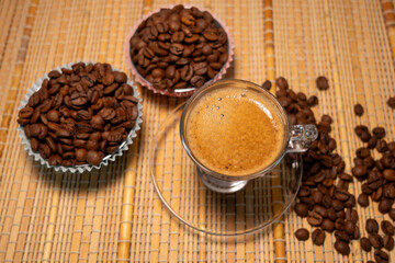 coffee and coffee beans on a straw tablecloth during an afternoon or morning coffee with beans arranged around