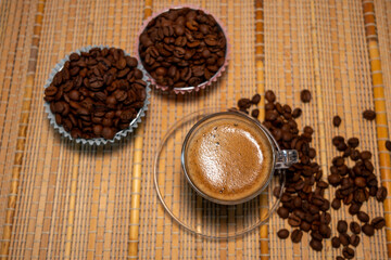 coffee and coffee beans on a straw tablecloth during an afternoon or morning coffee with beans arranged around