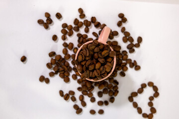 coffee grains falling into a cup or cupcake with coffee inside and symbols around it, creating a background