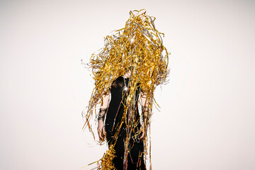 Woman Celebrating Wearing Gold Tinsel and Black Dress