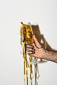 Elegant Hand Holding Champagne Glass with Golden Ribbon