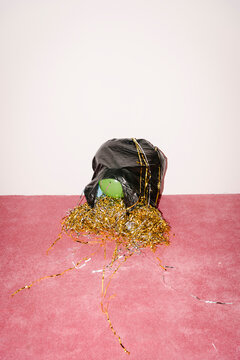 Trash Bag with Balloons and Tinsel on Pink Carpet