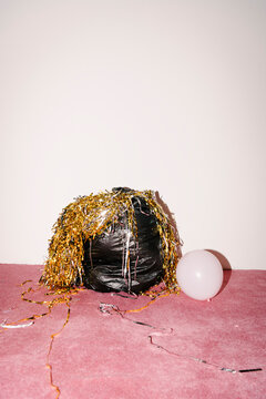 Party Aftermath With Balloon and Tinsel on Pink Carpet