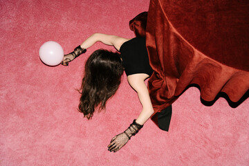 Woman Hidden Under Table on Pink Carpet with Balloon
