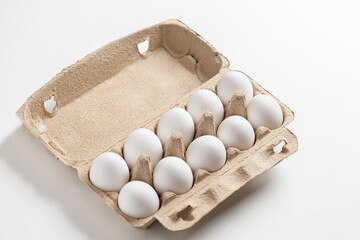 Carton of white eggs on white background