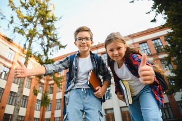 Happy children near the school. Friends boy and girl together in the school yard