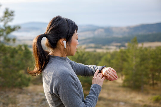 Active woman checking stopwatch while exercising