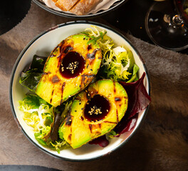 Grilled avocado with ponzu sauce served with mix of fresh greens, healthy food