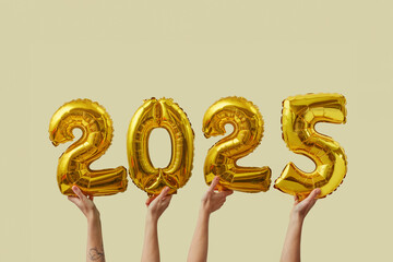 Hand holding balloons in shape of 2025