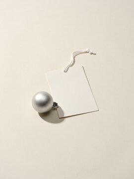 Elegant silver ornament with a blank gift tag on a smooth surface