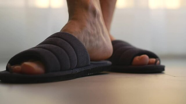 Slippers on feet close-up.
Shoes for the home.
Soft slaps for the home.
Soft slippers