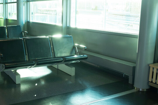 Black cozy bench on airport waiting room with sun rays & beam of light