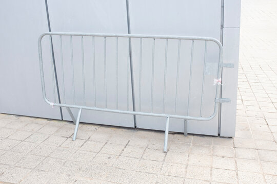 Metallic fence in front of silver metal wall in urban city environment