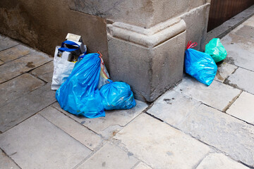 Bright blue plastic bags in a corner of concrete wall urban city 