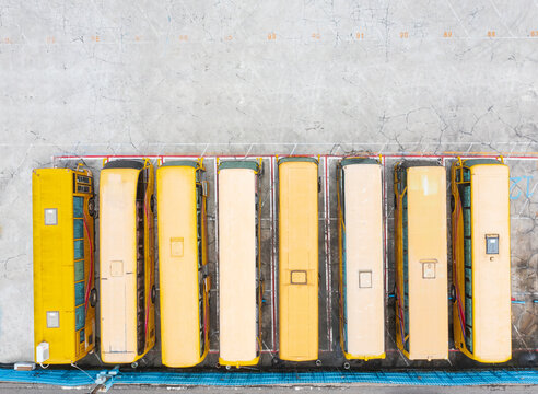 A Row of Large Yellow Buses Parked on Concrete