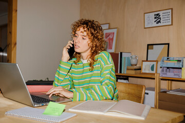 Freelancer working from home office and talking on phone