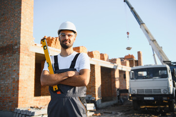 Construction worker in uniform and safety equipment have job on building. Industrial theme