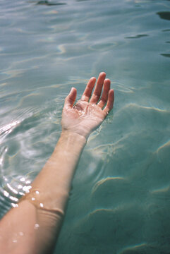 female hand in sea water